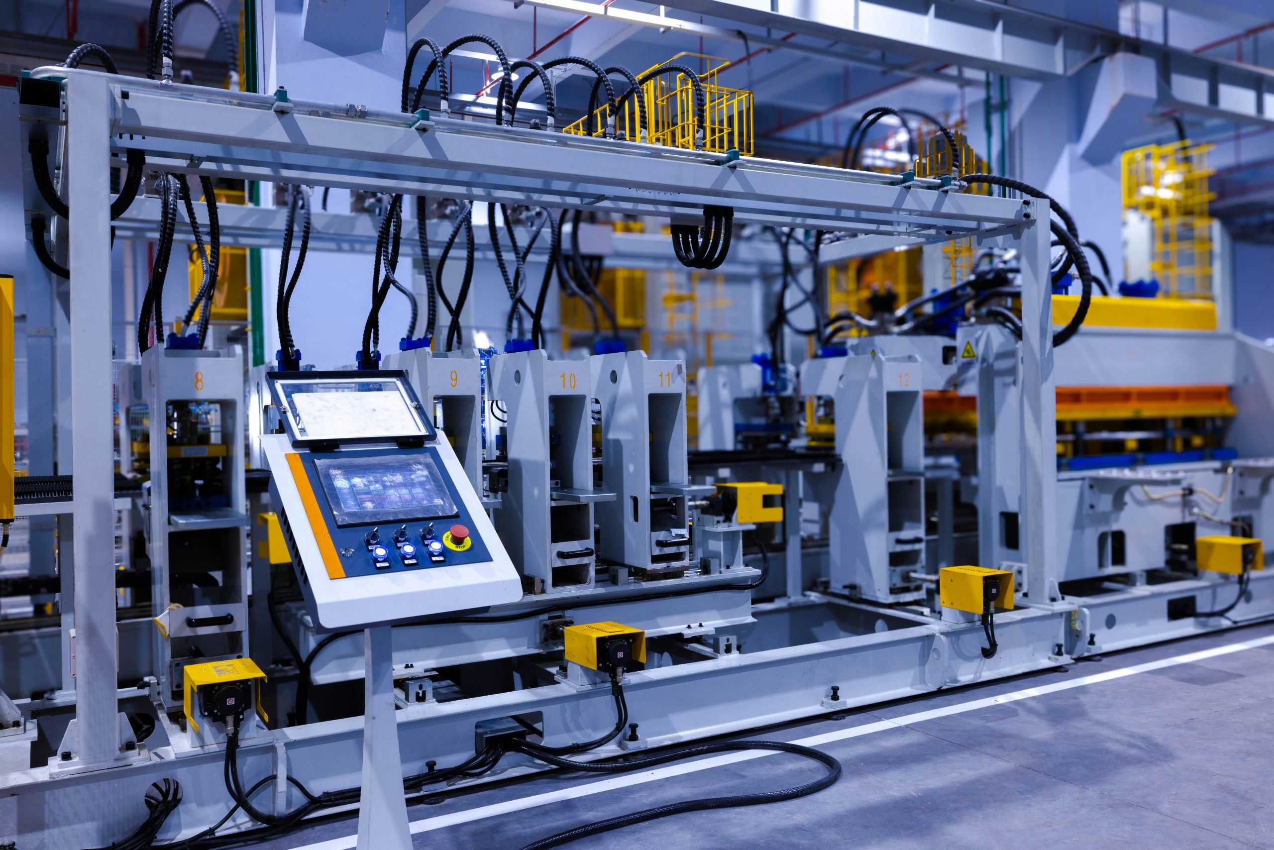 Automated production line with an HMI control panel and numbered machine stations in a factory